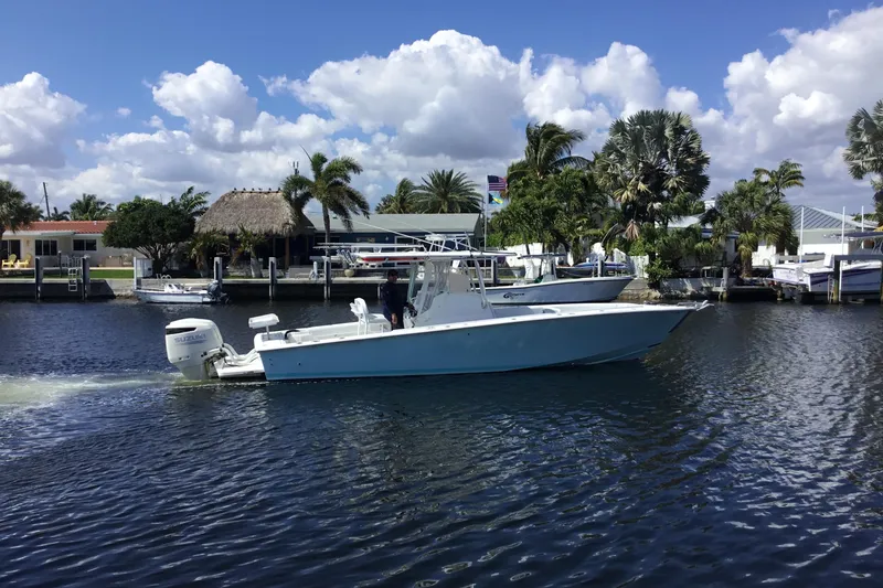 Slide: The Image of 2000 Jupiter 31 Center Console boat cruising on a sunny day near waterfront homes. - 63