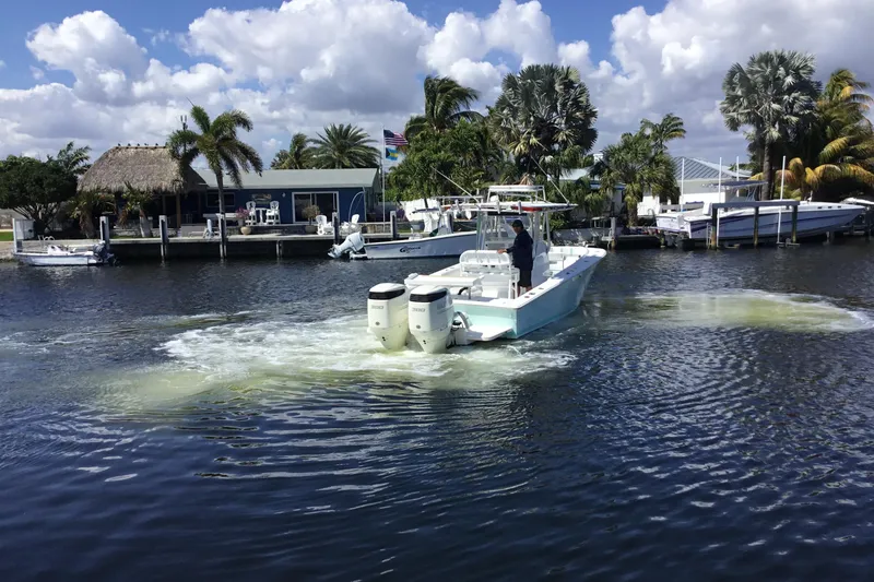 Slide: The Image of 2000 Jupiter 31 Center Console boat cruising on a scenic waterway with palm trees. - 65