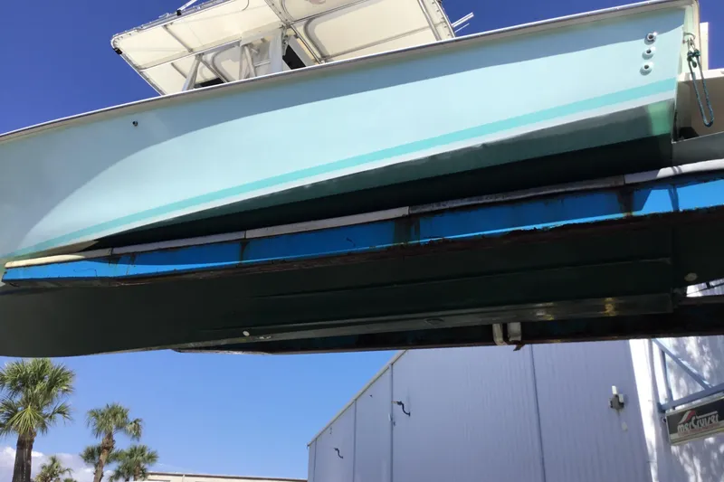 Slide: The Image of 2000 Jupiter 31 Center Console boat on lift, clear sky background. - 77