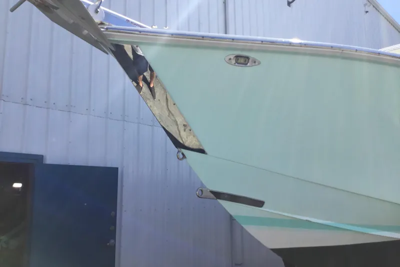 Slide: The Image of Damaged bow of 2000 Jupiter 31 Center Console boat near a building. - 78