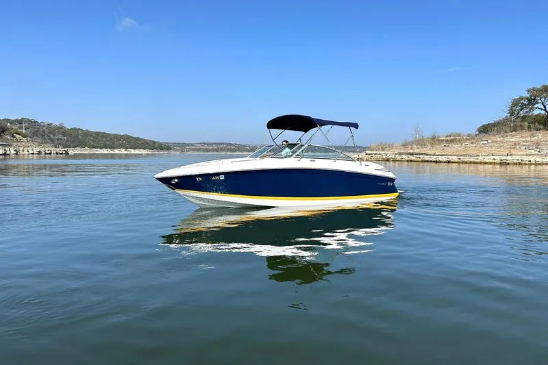 Slide: The Image of 2007 Cobalt 232 boat on calm lake with clear blue sky. - 13