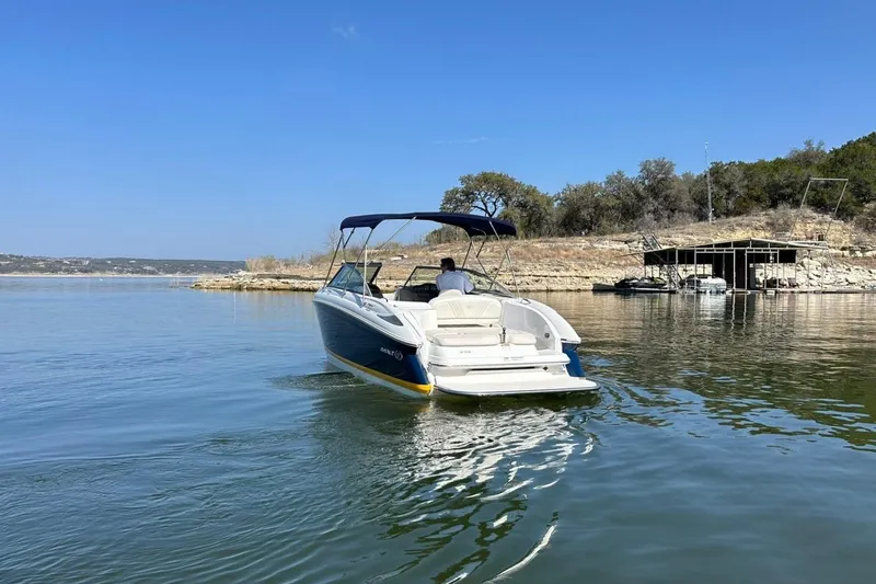 Slide: The Image of 2007 Cobalt 232 boat cruising on a calm lake under a clear blue sky. - 15