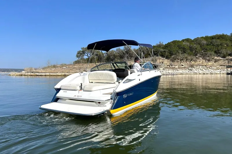 Slide: The Image of 2007 Cobalt 232 boat cruising on a serene lake under a clear blue sky. - 17