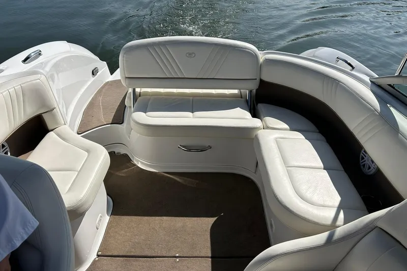 Slide: The Image of 2007 Cobalt 232 boat interior with white seating and carpeted floor on water. - 25