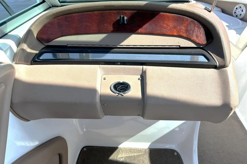 Slide: The Image of 2007 Cobalt 232 boat dashboard with wood accents and beige upholstery. - 30