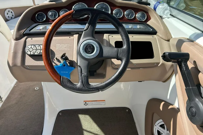 Slide: The Image of 2007 Cobalt 232 boat dashboard with steering wheel and control panel. - 32