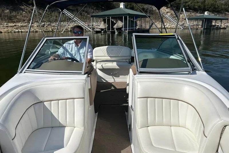 Slide: The Image of 2007 Cobalt 232 boat with white interior, docked on a calm lake. - 43