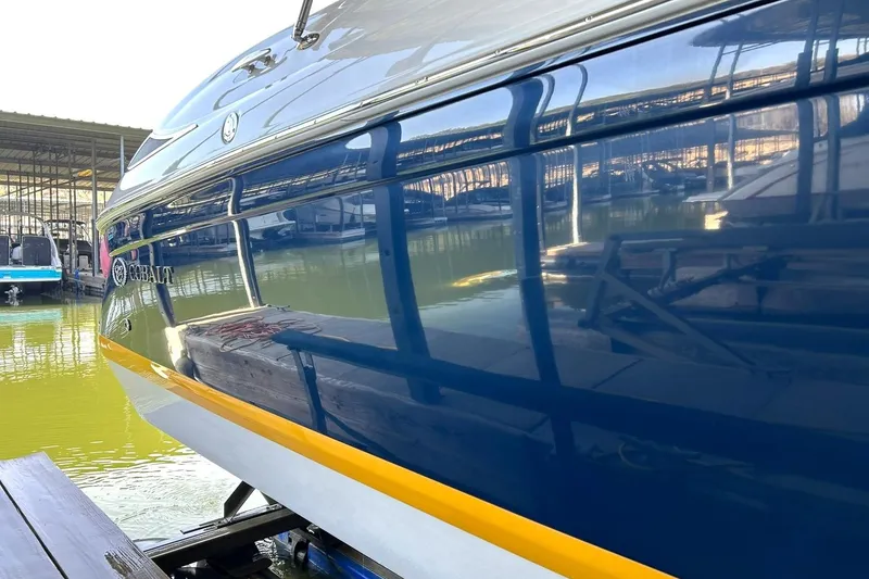 Slide: The Image of 2007 Cobalt 232 boat docked, reflecting marina surroundings on glossy blue hull. - 49