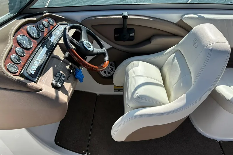 Slide: The Image of 2007 Cobalt 232 boat interior with steering wheel, gauges, and white captain's seat. - 5