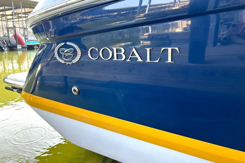 Slide: The Image of 2007 Cobalt 232 boat, blue and yellow hull, docked in marina. - 50
