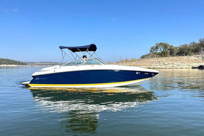 Slide: The Image of 2007 Cobalt 232 boat on calm lake with clear blue sky. - 7