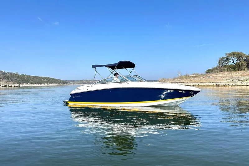 Slide: The Image of 2007 Cobalt 232 boat on a calm lake under a clear blue sky. - 8