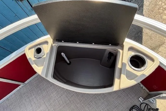 Slide: The Image of 2022 Sun Tracker Bass Buggy 18 DLX storage compartment with cup holders and open lid. - 10