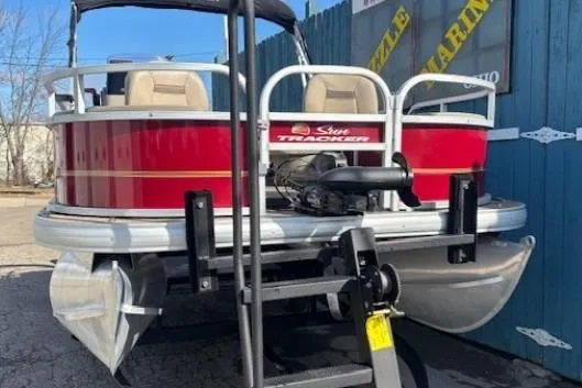 Slide: The Image of 2022 Sun Tracker Bass Buggy 18 DLX pontoon boat on trailer, red and white design. - 2