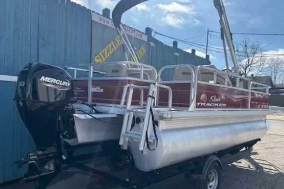 Slide: The Image of 2022 Sun Tracker Bass Buggy 18 DLX pontoon boat with Mercury engine, parked outdoors. - 3