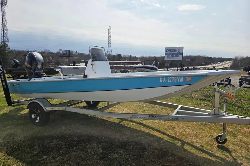 Slide: The Image of 2020 Xpress XP18CC boat on trailer, blue and white, parked outdoors. - 1
