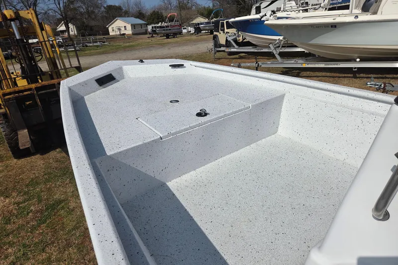 Slide: The Image of 2020 Xpress XP18CC boat interior with speckled white finish, parked outdoors. - 11