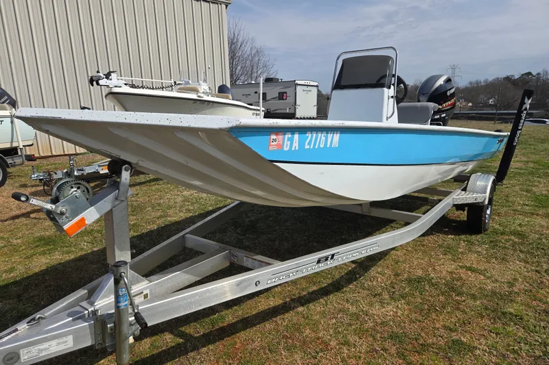 Slide: The Image of 2020 Xpress XP18CC boat on trailer, blue and white, parked outdoors. - 2