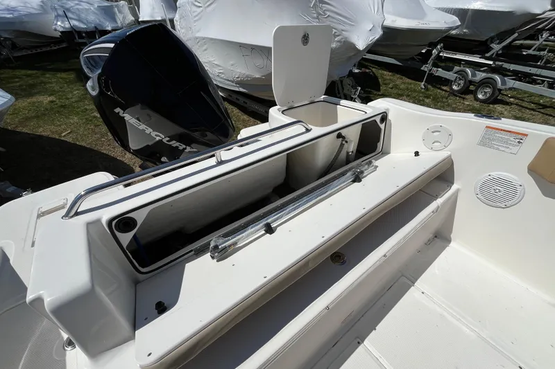 Slide: The Image of 2026 Bayliner Trophy T22SC boat interior with open storage compartment and Mercury engine. - 12