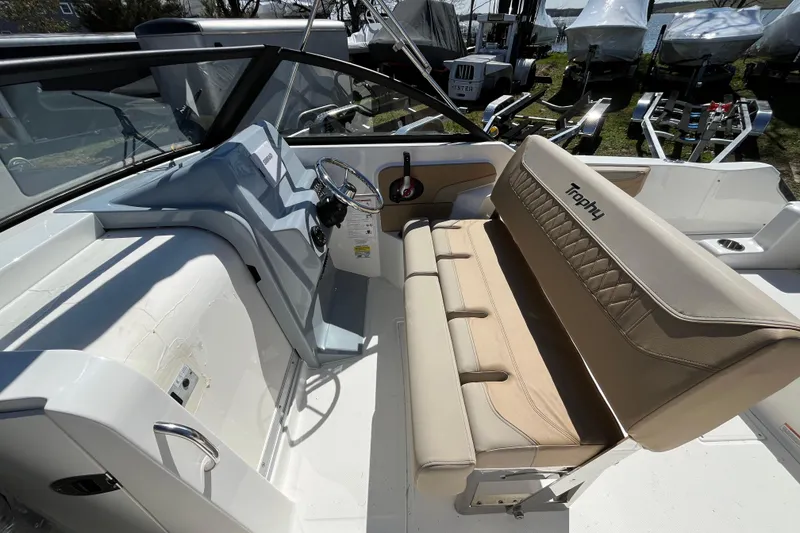 Slide: The Image of 2026 Bayliner Trophy T22SC boat interior with steering wheel and cushioned seating. - 13