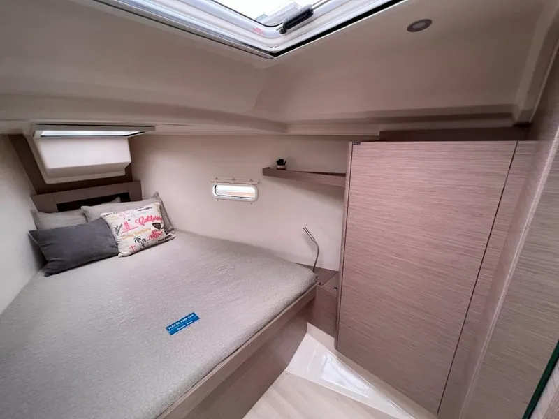 Slide: The Image of 2023 Hanse 388 yacht interior cabin with bed, pillows, and storage. - 24