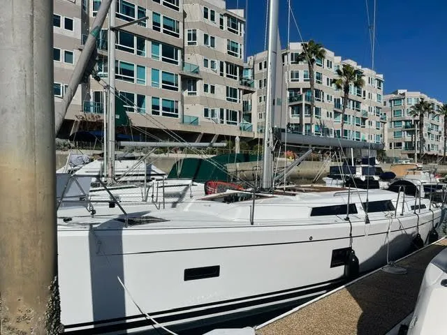 Slide: The Image of 2023 Hanse 388 sailboat docked near modern waterfront apartments. - 39