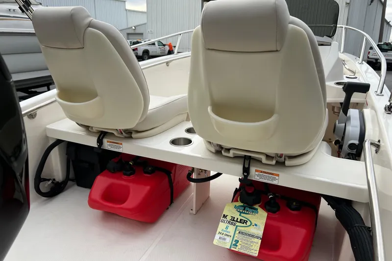 Slide: The Image of 2023 Boston Whaler 130 Super Sport interior with dual seats and red fuel tanks. - 3