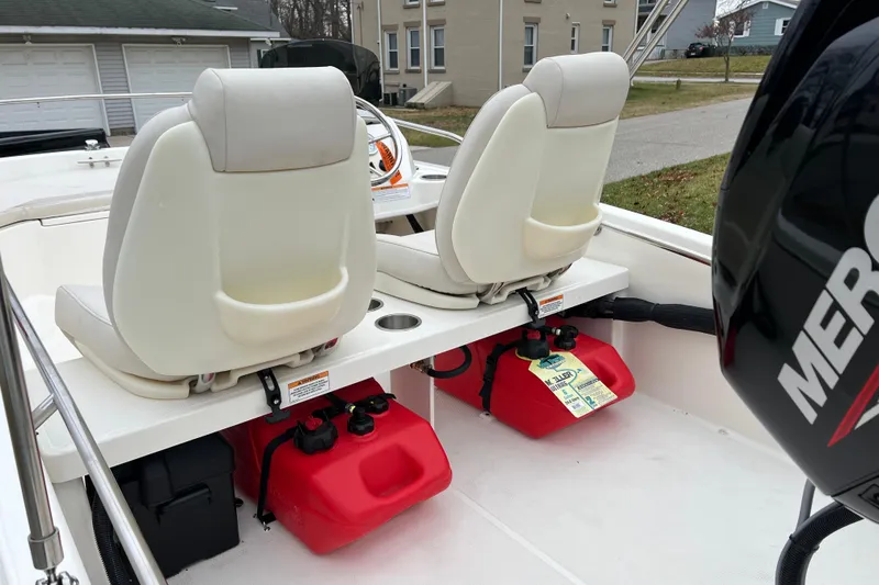 Slide: The Image of 2023 Boston Whaler 130 Super Sport interior with dual seats and red fuel tanks. - 4