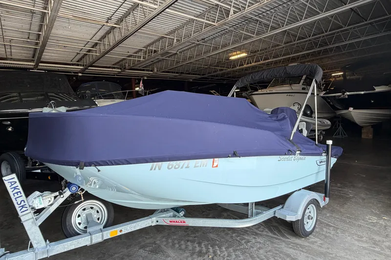 Slide: The Image of 2023 Boston Whaler 130 Super Sport boat covered in storage on a trailer. - 5