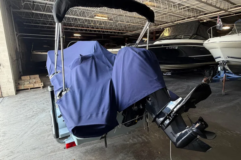 Slide: The Image of 2023 Boston Whaler 130 Super Sport covered in storage, showcasing outboard motor. - 7
