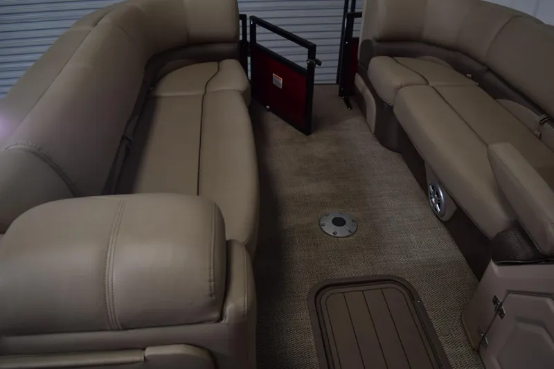 Slide: The Image of 2022 Regency 230 DL3 boat interior with beige seating and carpeted flooring. - 10