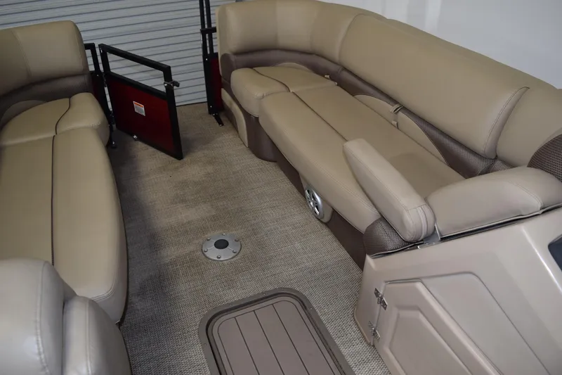 Slide: The Image of 2022 Regency 230 DL3 boat interior with beige seating and carpeted flooring. - 11