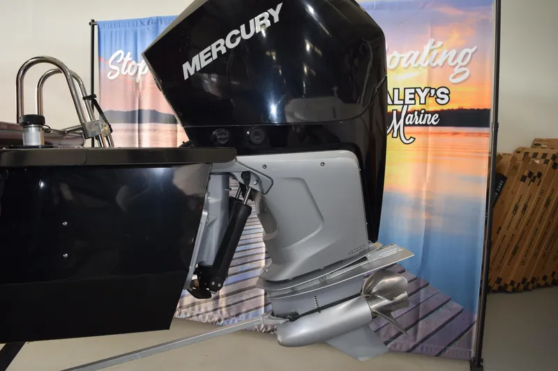 Slide: The Image of 2022 Regency 230 DL3 boat with Mercury outboard motor displayed at a marine showroom. - 14