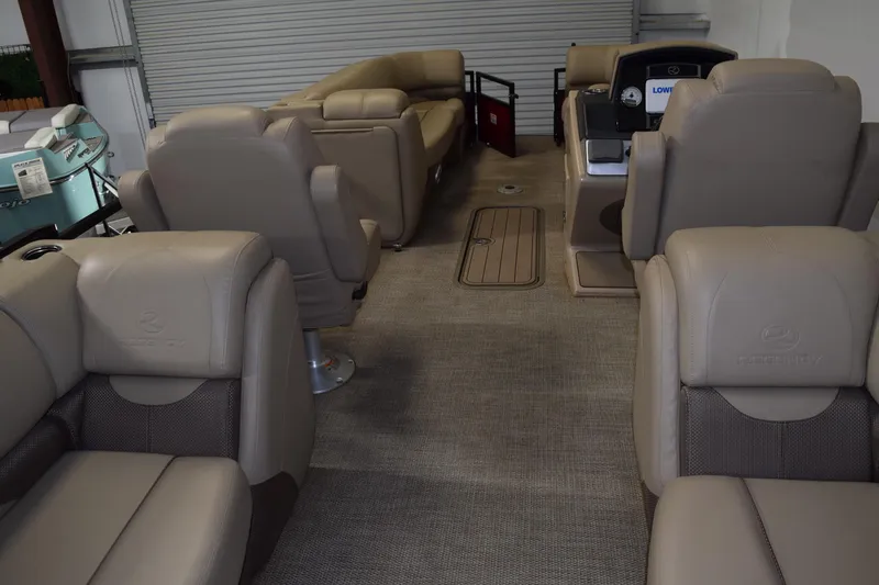 Slide: The Image of 2022 Regency 230 DL3 pontoon boat interior with beige seating and carpeted flooring. - 3