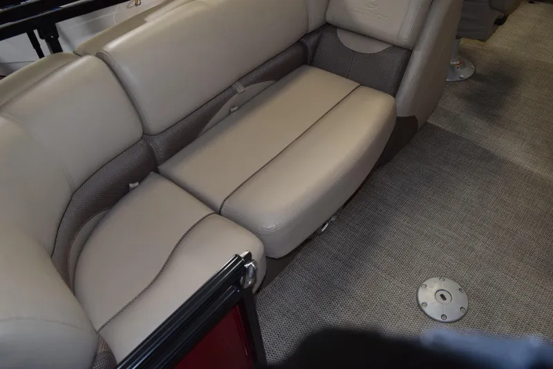 Slide: The Image of 2022 Regency 230 DL3 boat interior with beige cushioned seating and carpeted flooring. - 5