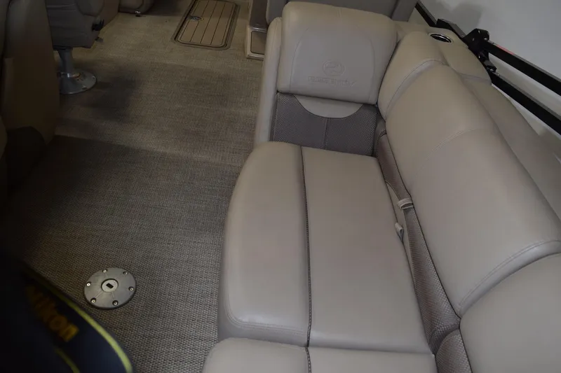Slide: The Image of 2022 Regency 230 DL3 boat interior with beige seating and carpeted flooring. - 6