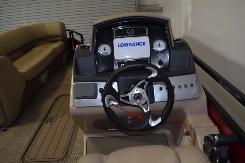 Slide: The Image of 2022 Regency 230 DL3 boat dashboard with Lowrance display and steering wheel. - 7
