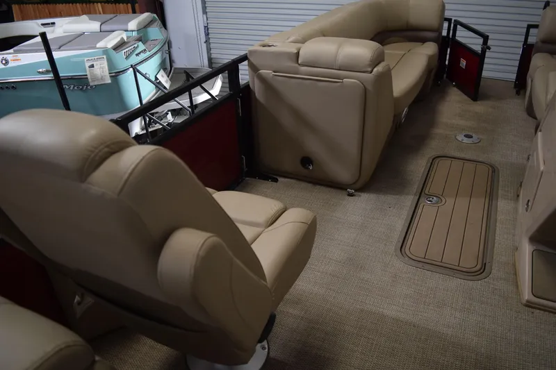 Slide: The Image of 2022 Regency 230 DL3 boat interior with beige seating and carpeted flooring. - 8