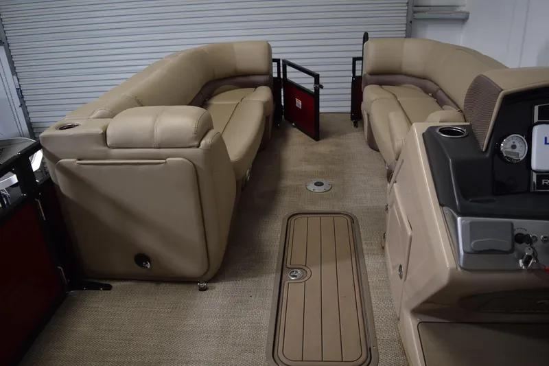 Slide: The Image of Interior of 2022 Regency 230 DL3 pontoon boat with beige seating and control panel. - 9