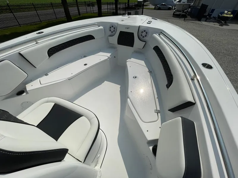 Slide: The Image of 2025 Tidewater 232 CC Adventure boat interior with white seating and storage compartments. - 11