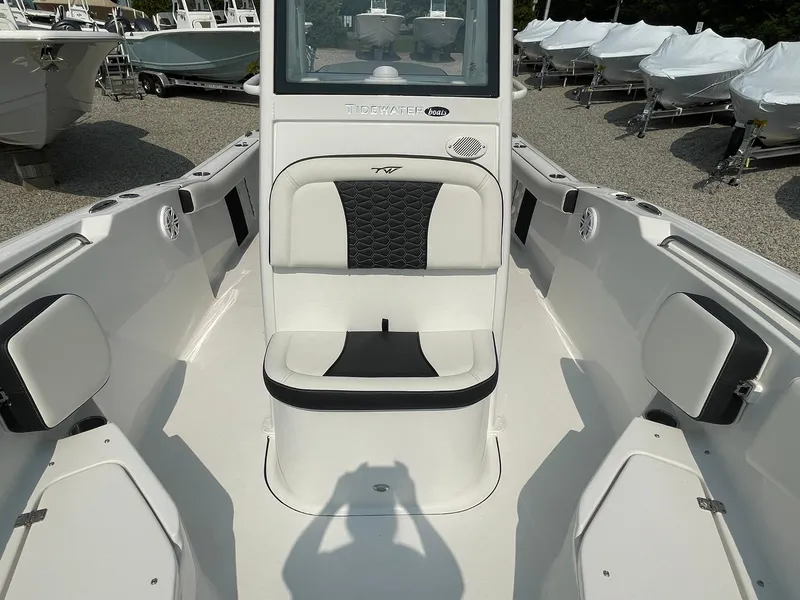 Slide: The Image of 2025 Tidewater 232 CC Adventure boat interior with seating and console, displayed outdoors. - 15