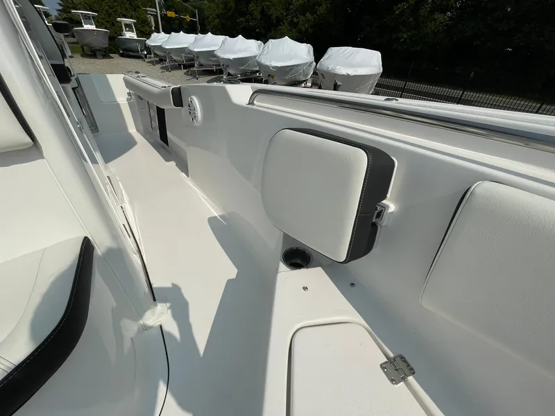 Slide: The Image of 2025 Tidewater 232 CC Adventure boat interior with sleek white seating and storage compartments. - 17