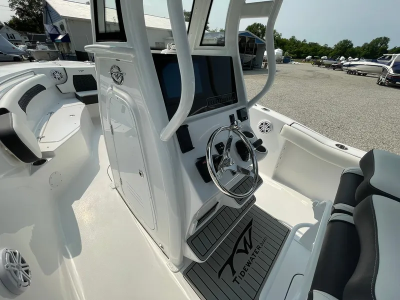 Slide: The Image of 2025 Tidewater 232 CC Adventure boat interior with steering console and seating. - 21