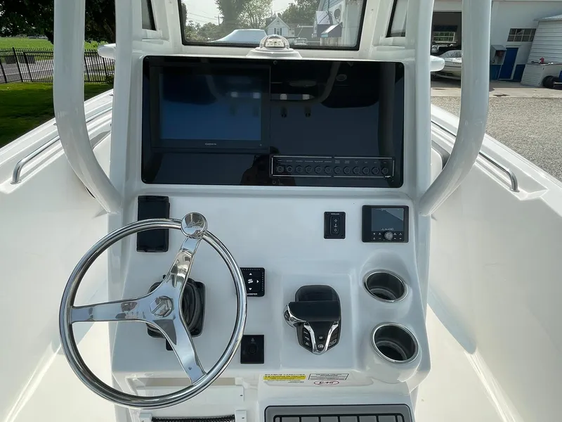 Slide: The Image of 2025 Tidewater 232 CC Adventure boat console with steering wheel, controls, and display screens. - 23