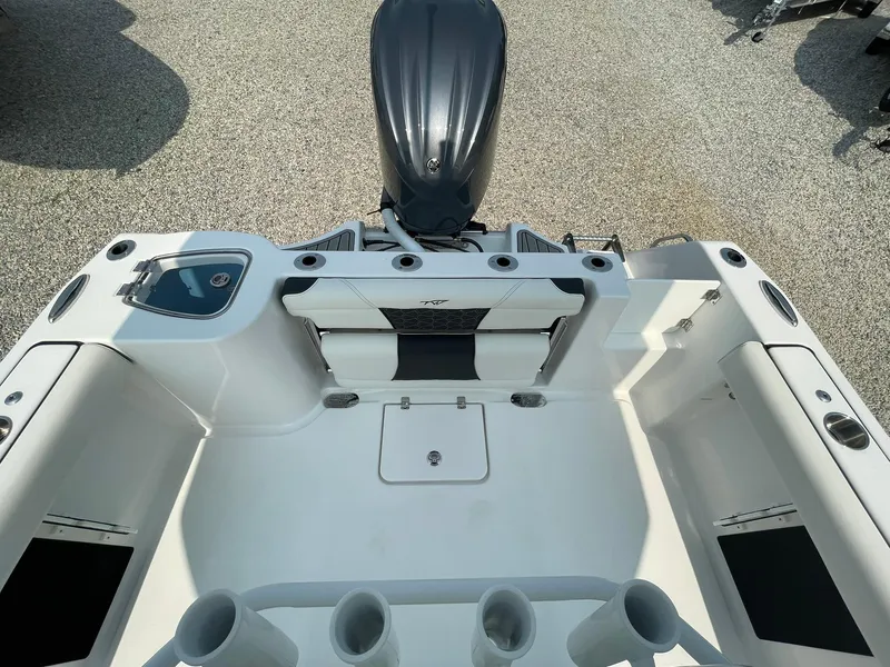 Slide: The Image of 2025 Tidewater 232 CC Adventure boat interior with motor, rod holders, and seating. - 33