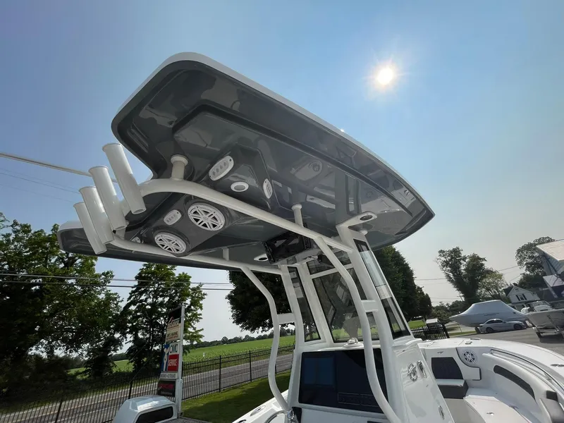 Slide: The Image of 2025 Tidewater 232 CC Adventure boat with T-top under sunny sky. - 45