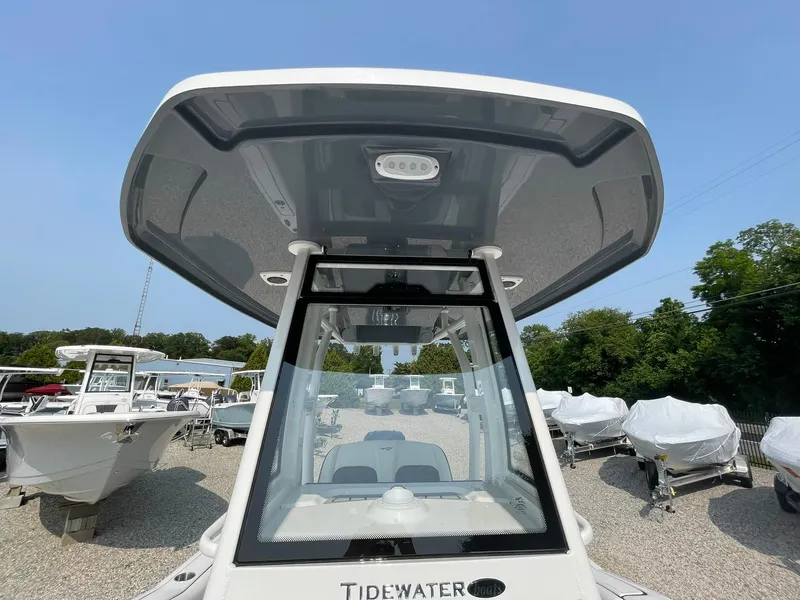 Slide: The Image of 2025 Tidewater 232 CC Adventure boat with T-top, displayed outdoors. - 46