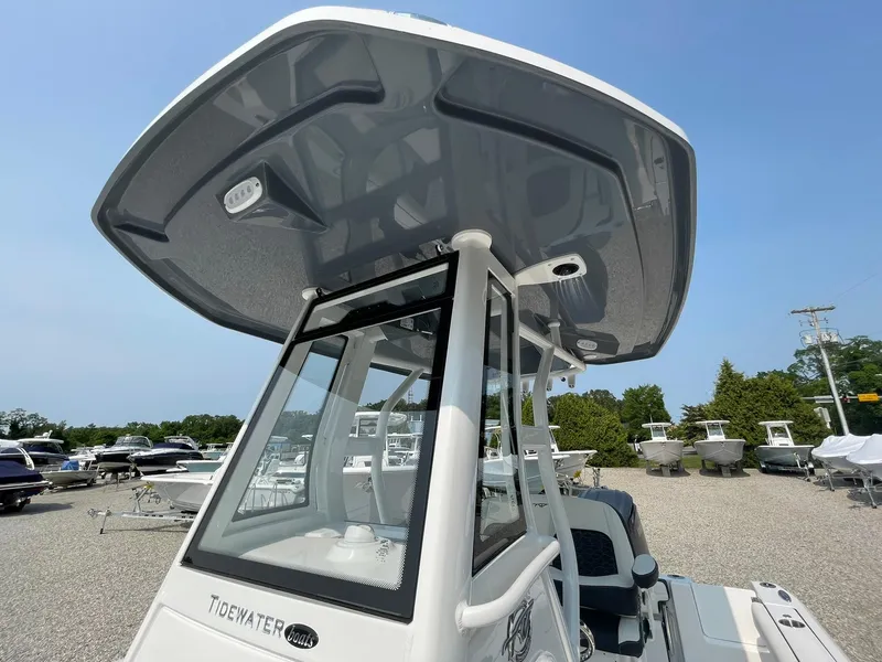 Slide: The Image of 2025 Tidewater 232 CC Adventure boat with T-top, parked in a marina. - 47