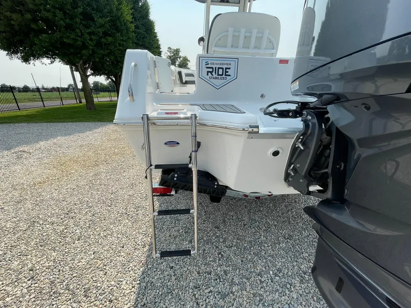 Slide: The Image of 2025 Tidewater 232 CC Adventure boat with ladder on gravel surface. - 55