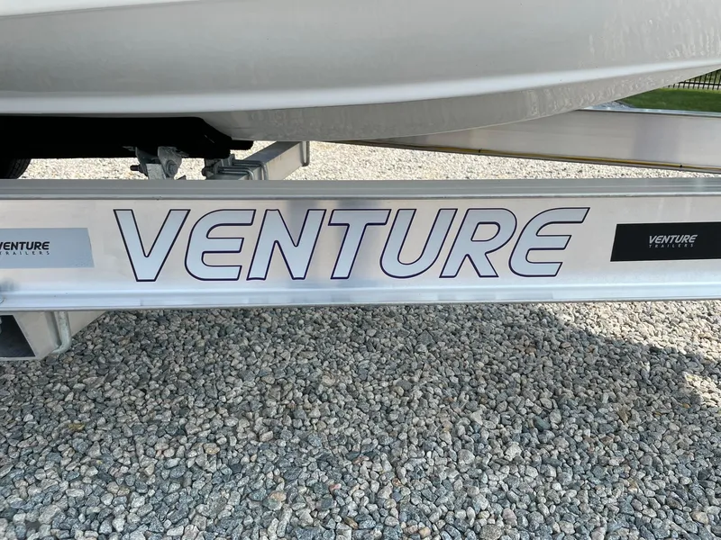 Slide: The Image of Trailer for 2025 Tidewater 232 CC Adventure boat on gravel surface. - 57